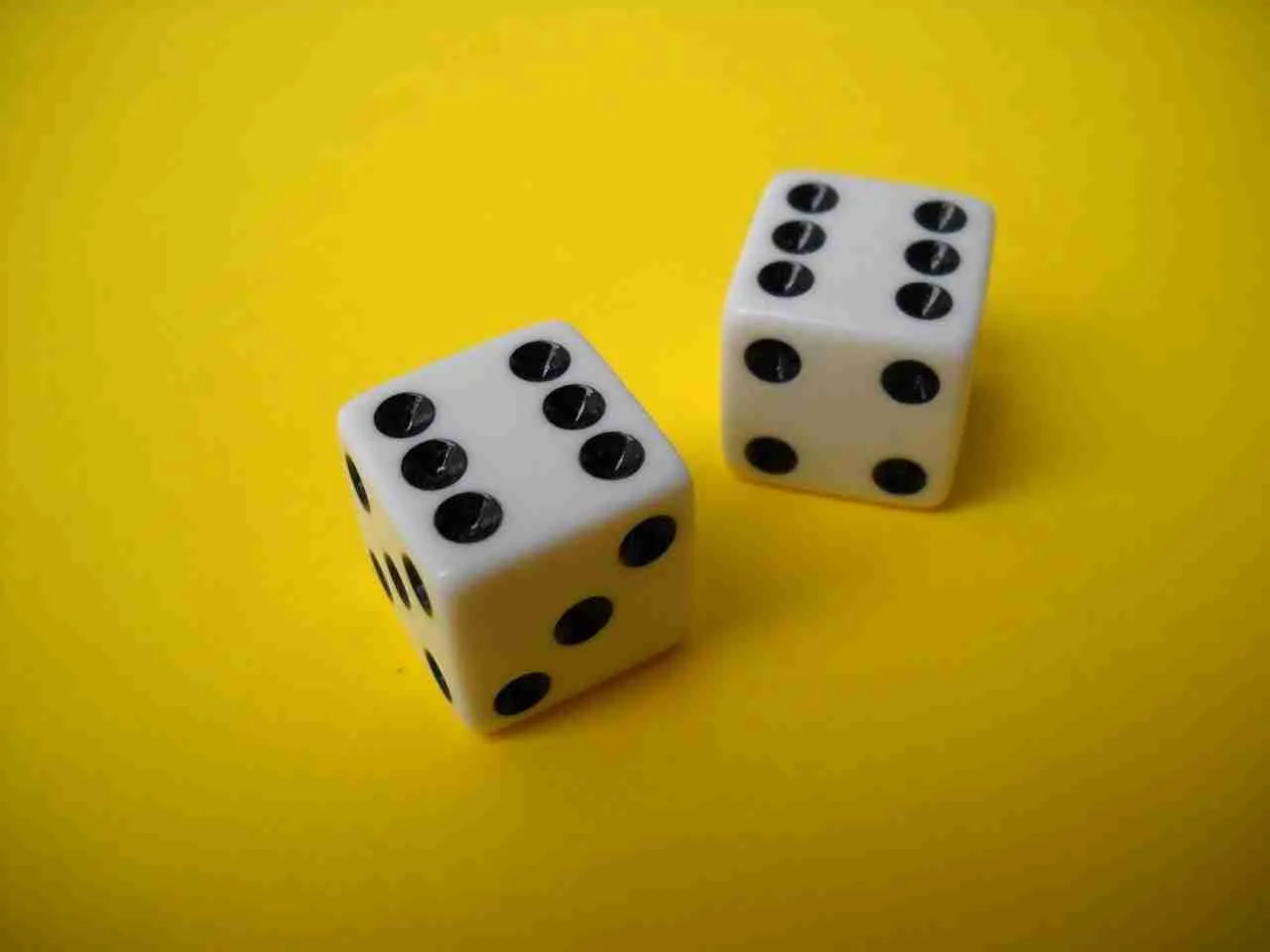 Two six-sided dice showing different numbers against a yellow background.