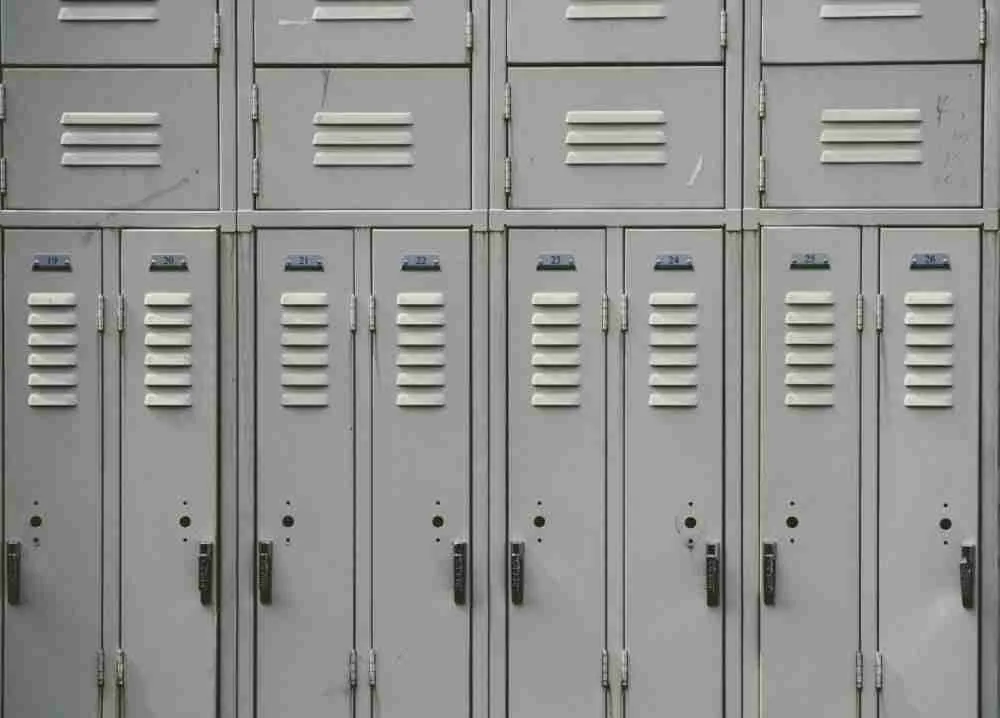 A row of closed gray metal lockers with name card slots and combination locks, suggesting a secure storage area in a school or gym setting, has been featured in a detailed MyThemeShop content locker review